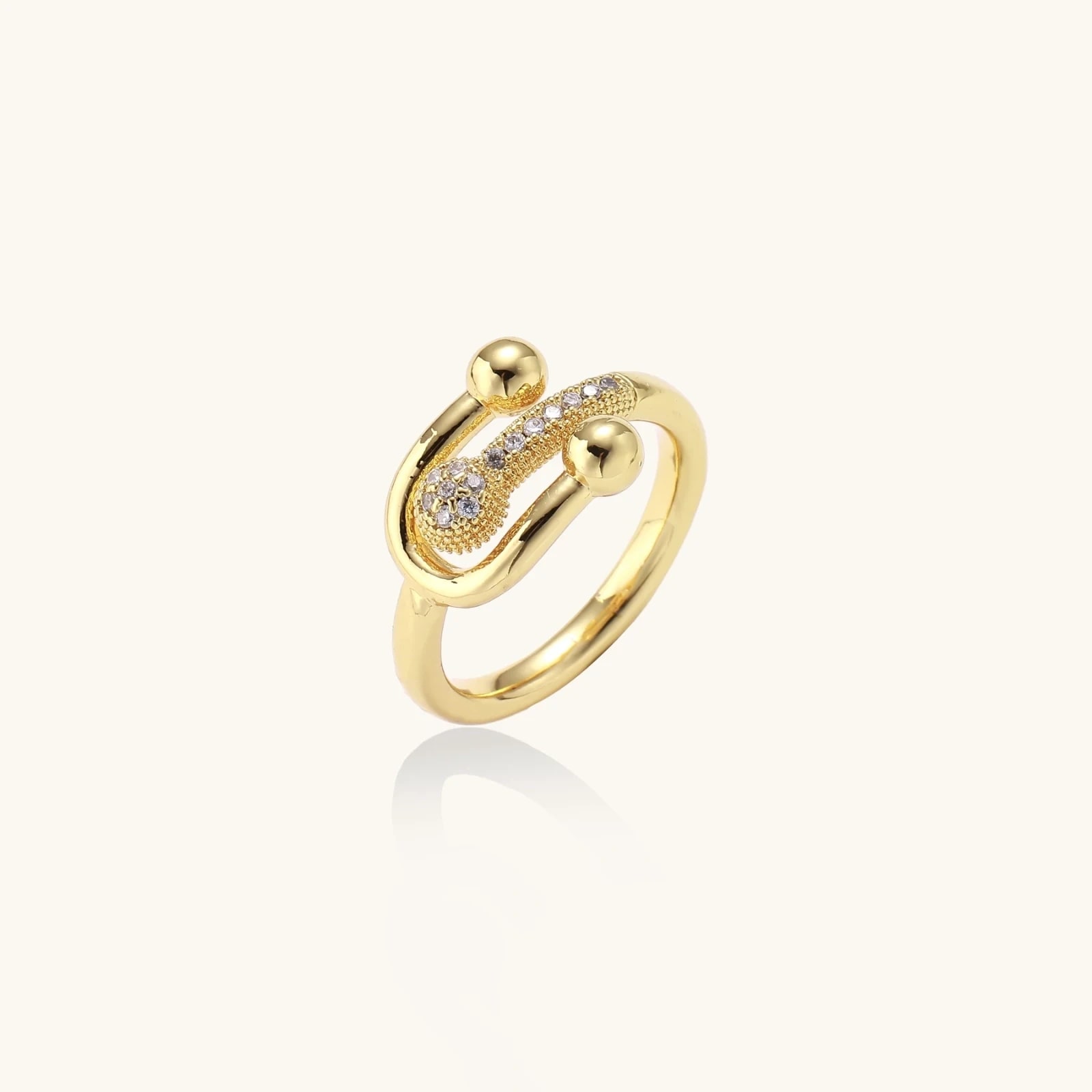 Bague Épingle de Sûreté, laiton doré à l’or 18 carats · oxydes de zirconium, photographie du bijou sur fond clair